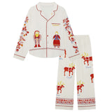 A two-piece Big Folk pajama set featuring a long-sleeve button-front top and matching pants in an off-white fabric. The pajamas are decorated with red and multicolor festive illustrations, including a Santa Claus figure, a reindeer, and Nordic-style patterns with text labels.