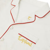 Close-up of a Big Folk pyjama top with red piping trim and yellow embroidered text reading 'Lapland' on the chest pocket.